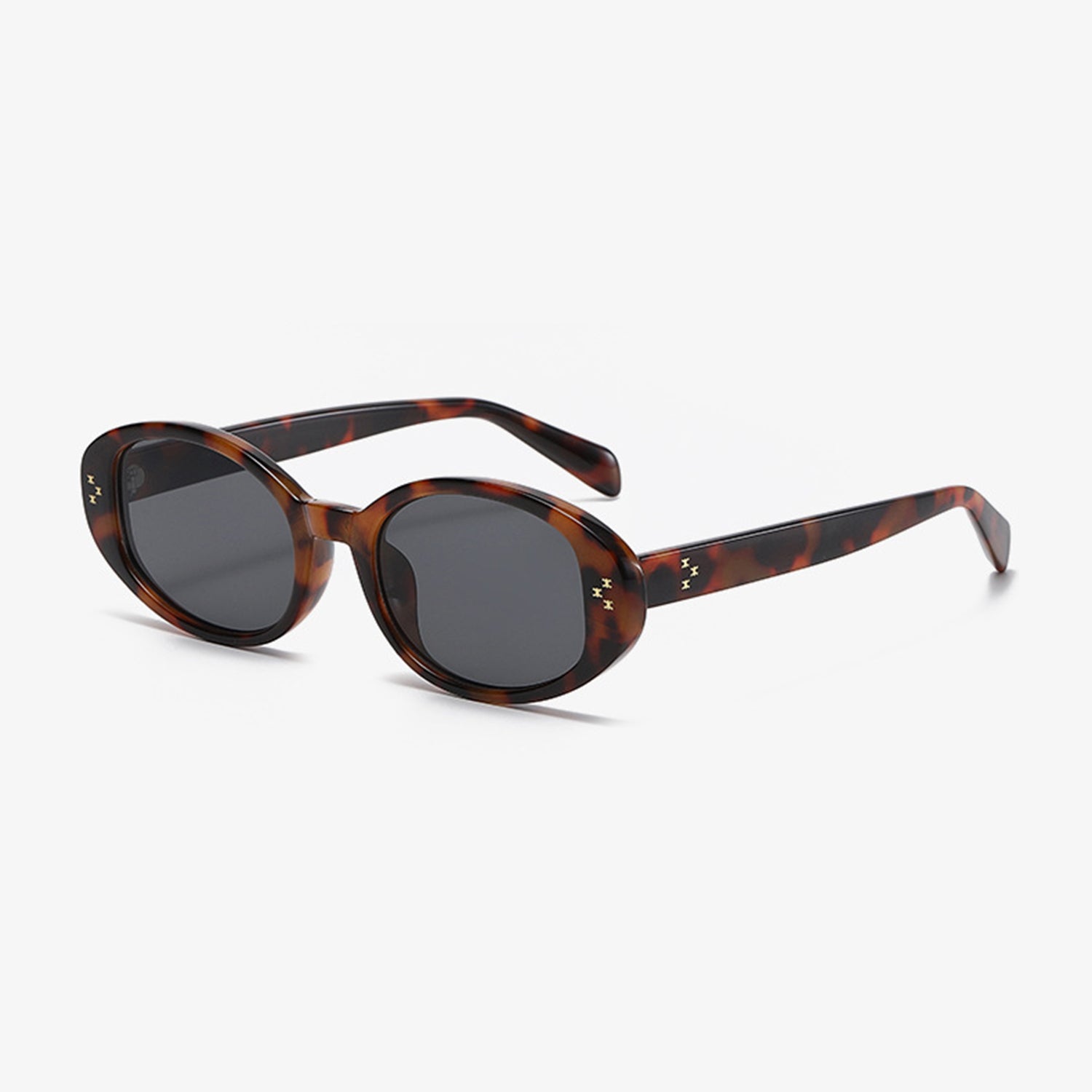 Marianela's Exclusive Shop, LLC offers a stylish pair of Polycarbonate Frame Oval Sunglasses featuring UV400 dark lenses. The frames display a brown and amber mottled pattern with small decorative gold stars on the temples near the hinge, all set against a white background.