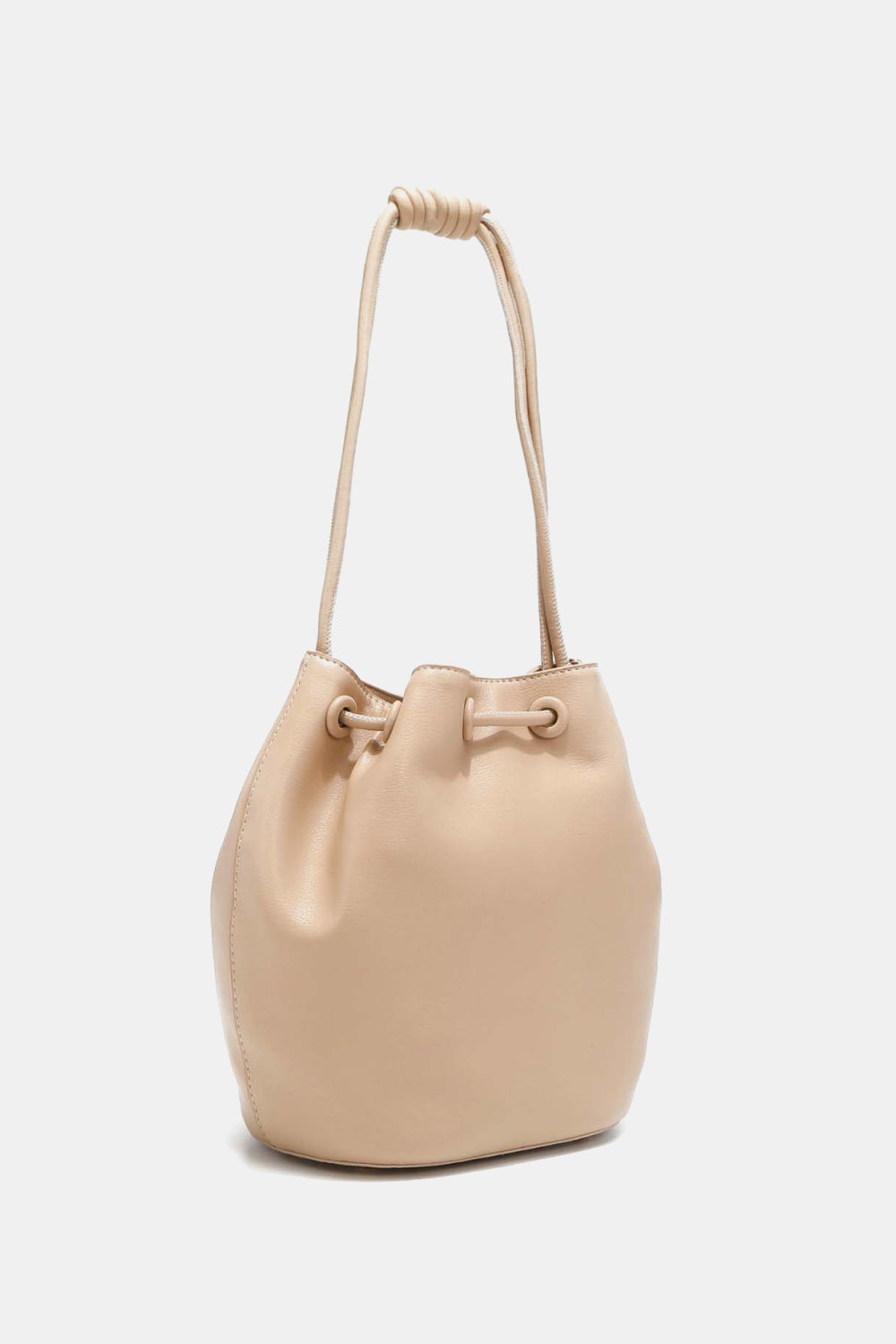 The Nicole Lee USA Amy Studded Bucket Bag, available at Marianela's Exclusive Shop, LLC, is a light beige drawstring bucket bag crafted from pebbled vegan leather with a smooth finish. The bag features a knotted shoulder strap and cinches closed with drawstring detailing near the top. The bottom is rounded, giving the bag a casual yet stylish look.