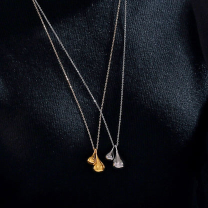 Set against a black fabric backdrop, two delicate necklaces glisten. The first is the "Elysian Gold Water Drop Necklace" from Marianela's Exclusive Shop, featuring an 18K gold plated design with water drop shape pendants, while the other features stainless steel pendants. Both thin and elegant chains seamlessly complement one another.