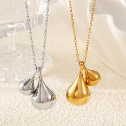 Here’s a version of your sentence using the provided product data:

Two necklaces showcasing water drop pendant designs are beautifully displayed on a soft, textured surface. Marianela's Exclusive Shop offers these exquisite pieces: The silver necklace is crafted from stainless steel and features three pendants, while the Elysian Gold Water Drop Necklace is 18K gold-plated and showcases two pendants.