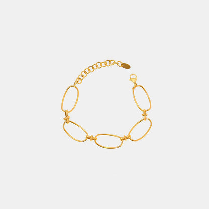 The Gold Hollow Chain Bracelet from Marianela's Exclusive Shop is a breathtaking piece, featuring large oval links crafted in 18K gold plating, elegantly arranged in a circle against a plain white backdrop. This contemporary design includes a small, adjustable titanium steel chain and clasp to ensure secure fastening.