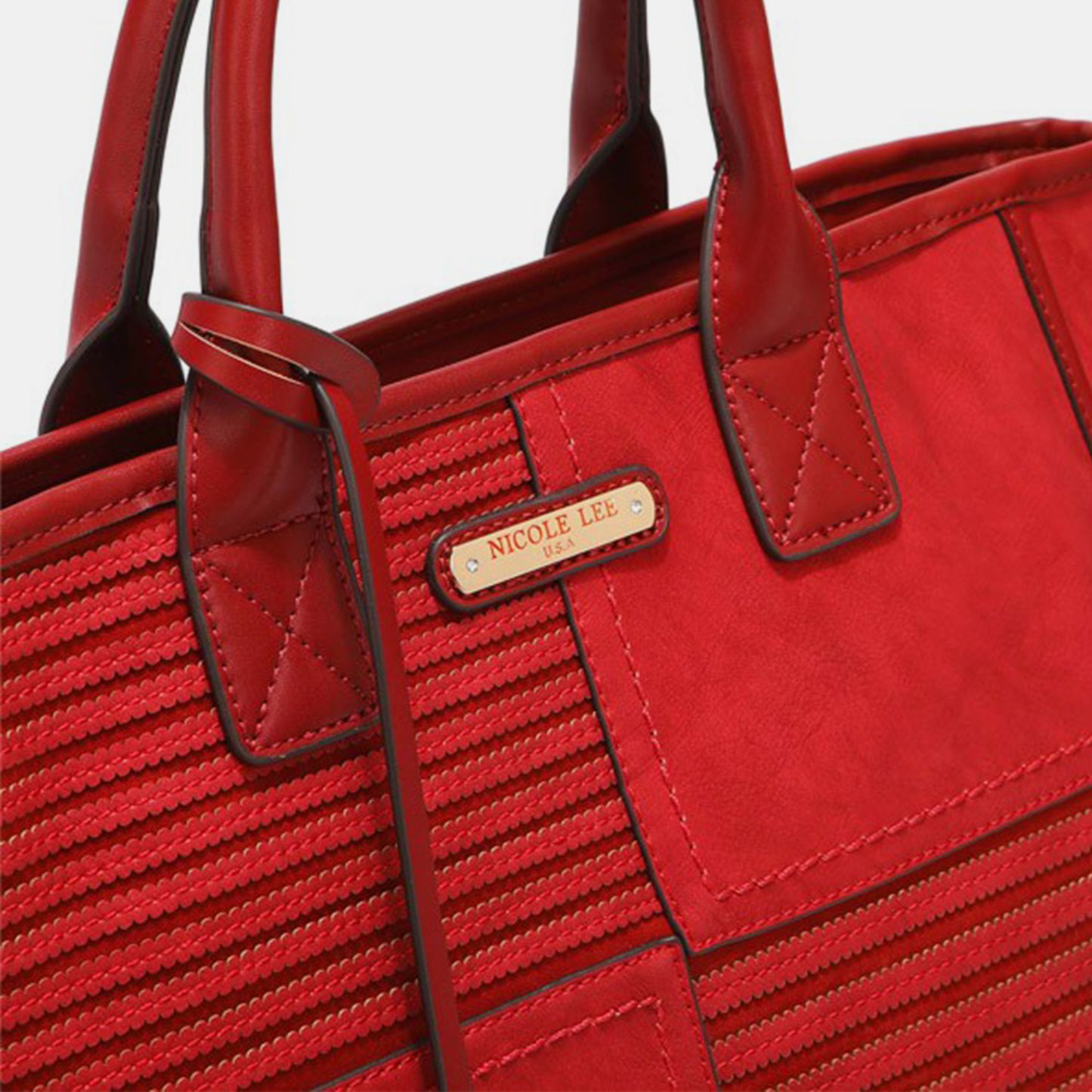 Close-up image of the Nicole Lee USA Scallop Stitched Handbag, available at Marianela's Exclusive Shop, LLC. This red vegan leather handbag features scallop-stitched detailing and dual handles. A gold-colored metal nameplate on the front reads "NICOLE LEE USA." The bag boasts a stylish, modern design with detailed craftsmanship, making it an elegant accessory for any occasion.