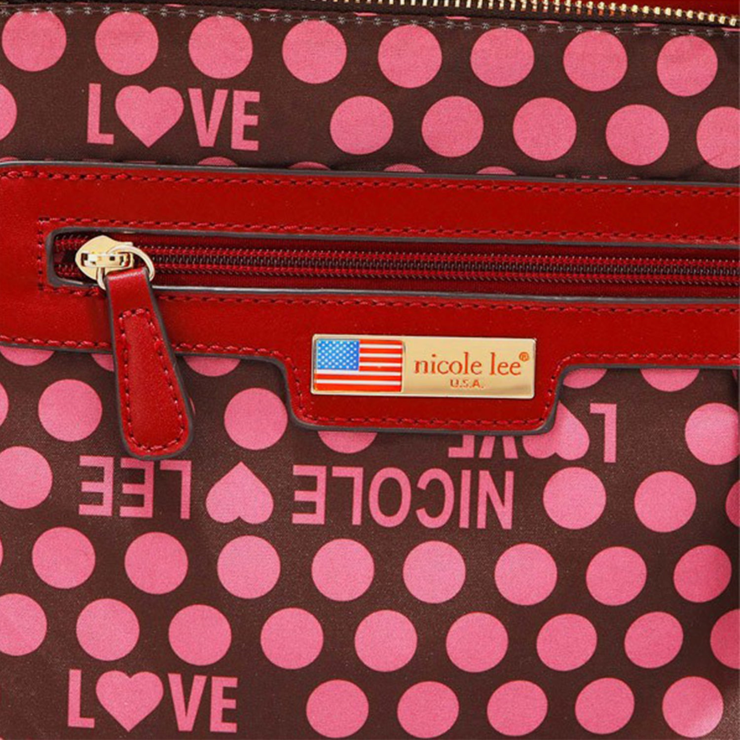 A close-up of an elegant Nicole Lee USA Scallop Stitched Handbag from Marianela's Exclusive Shop, LLC, featuring pink polka dots and the word "LOVE" written in pink. It includes a red zipper pocket with a red leather tag above it, showcasing an American flag and the text "nicole lee® U.S.A." in gold.