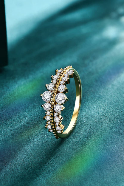 A stunning Moissanite 925 Sterling Silver Ring by Marianela's Exclusive Shop, LLC showcases a row of sparkling round stones set against a textured green surface and illuminated by beams of light.