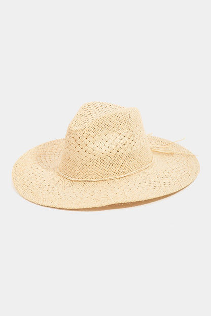 Introducing the Fame Straw Braided Sun Hat from Marianela's Exclusive Shop, LLC—a beige, wide-brimmed straw hat crafted with a simple woven design. This elegant accessory features a pinched crown and comes in a natural, undyed color, making it the perfect classic addition to your summer wardrobe. The wide brim ensures ample shade for optimal sun protection.