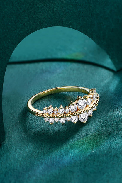 A Moissanite 925 Sterling Silver Ring from Marianela's Exclusive Shop, LLC, beautifully captures the elegance of a gold ring adorned with two rows of sparkling diamonds, arranged in a graceful curve against a luxurious green velvet backdrop.