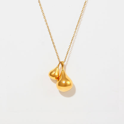 The Elysian Gold Water Drop Necklace from Marianela's Exclusive Shop features an 18K gold-plated design with two elegant water drop pendants on a fine chain, set against a white background. The pendants' smooth, reflective surface adds sophistication to this exquisite piece.