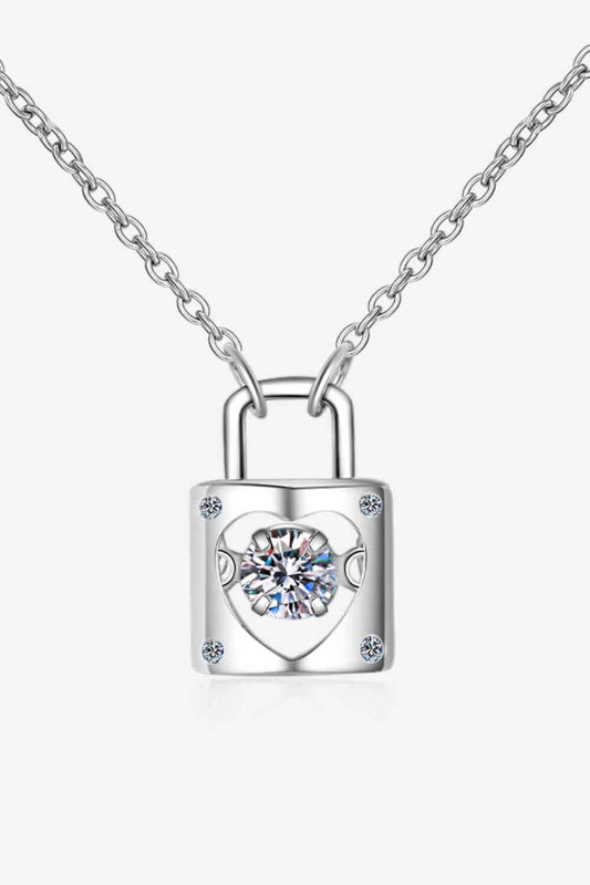 A delicate Adored Moissanite Lock Pendant Necklace by Marianela's Exclusive Shop, LLC features a small padlock-shaped pendant with a heart cut-out center. Inside the heart, there is a sparkling moissanite gem. The pendant is attached to a fine chain, creating an elegant and minimalist design.