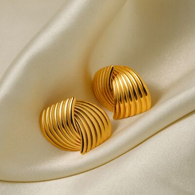 A pair of elegant, gold-toned Texture Stainless Steel Stud Earrings from Marianela's Exclusive Shop, LLC placed on a smooth, off-white satin fabric. The earrings feature a textured design resembling seashells, adding a touch of modern elegance and sophistication to their appearance.